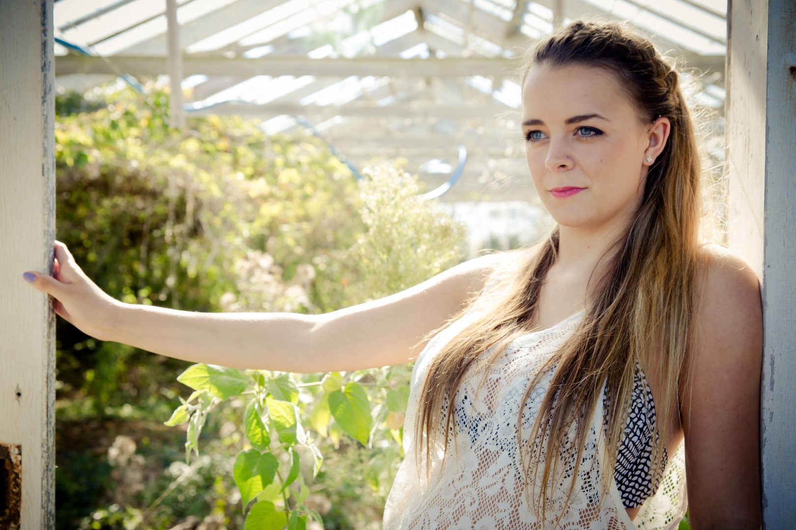 Natural-light fashion portrait among greenhouse plants